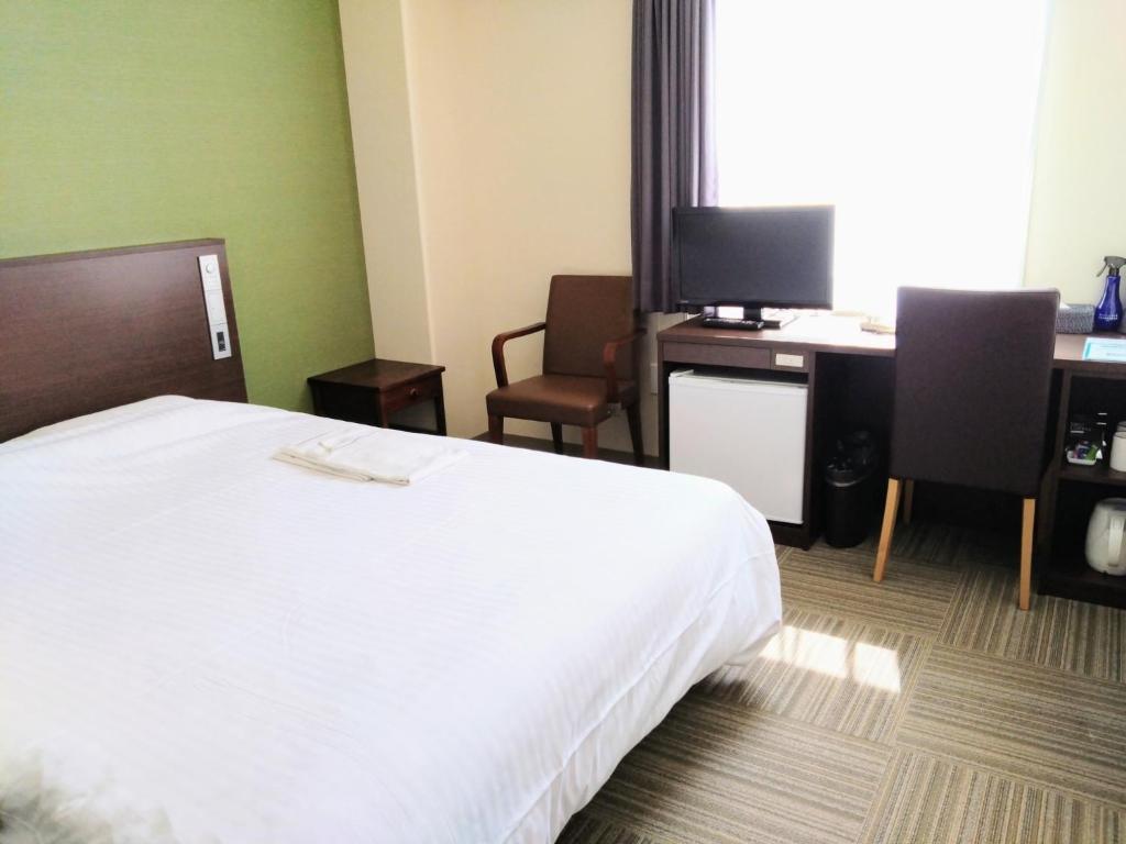 a hotel room with a bed and a desk with a computer at New Matto Terminal Hotel - Vacation STAY 01873v in Hakusan