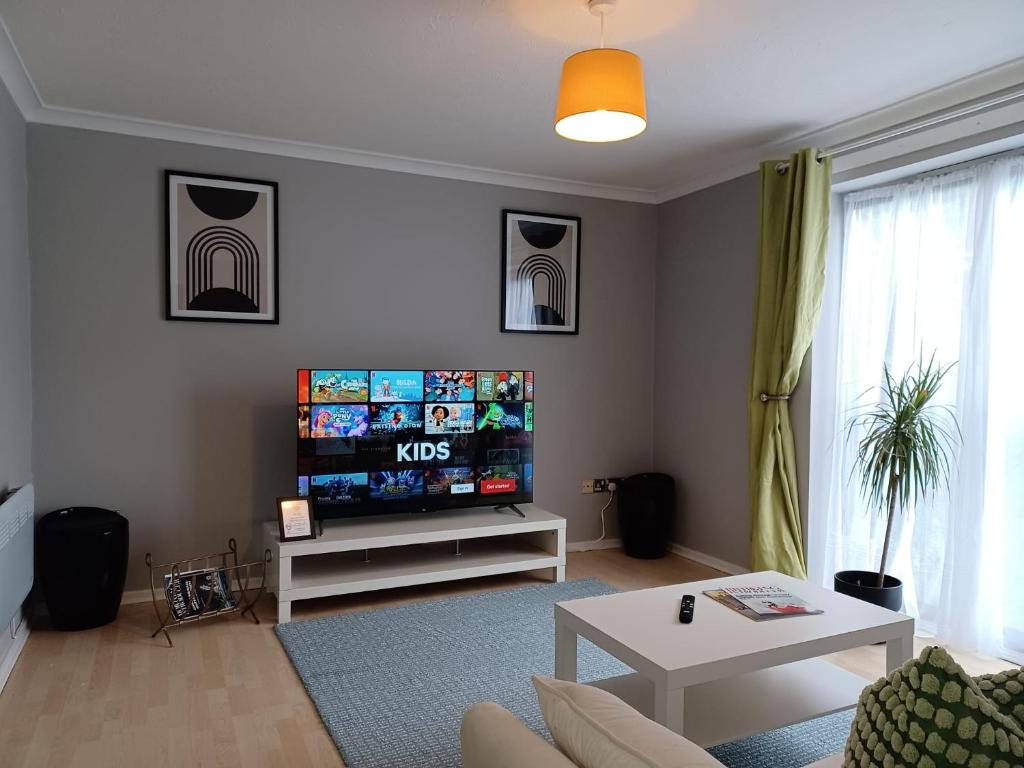 a living room with a flat screen tv on a wall at Green Door-The Malting- Specious 1st Floor-One Bedroom Apartment -Fully Furnished-Quiet- Free Parking -Dunstable in Dunstable