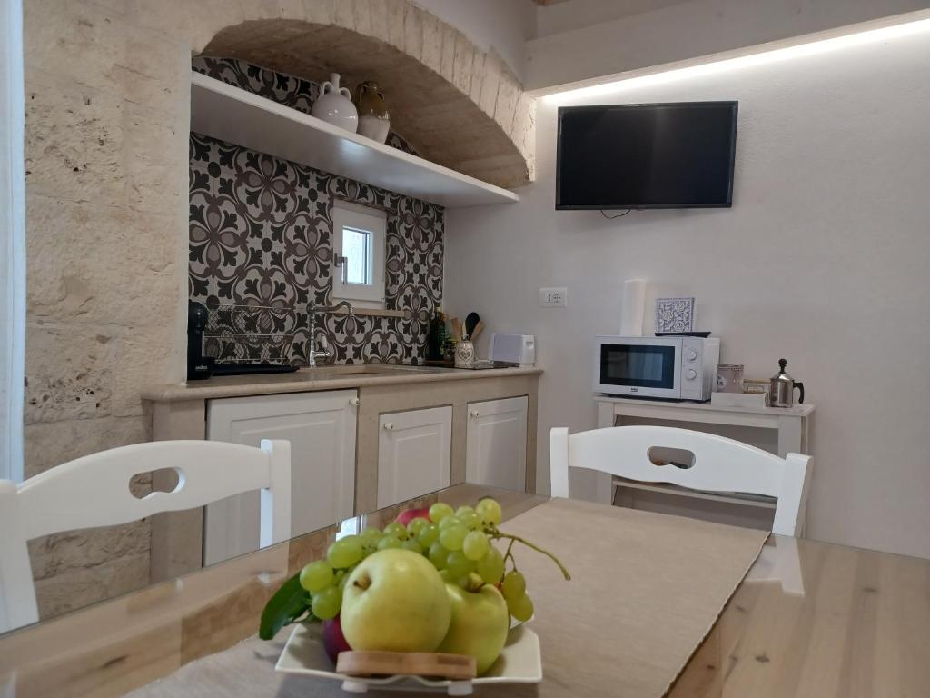 - une cuisine avec une table et un bouquet de fruits dans l'établissement I due campanili, à Alberobello