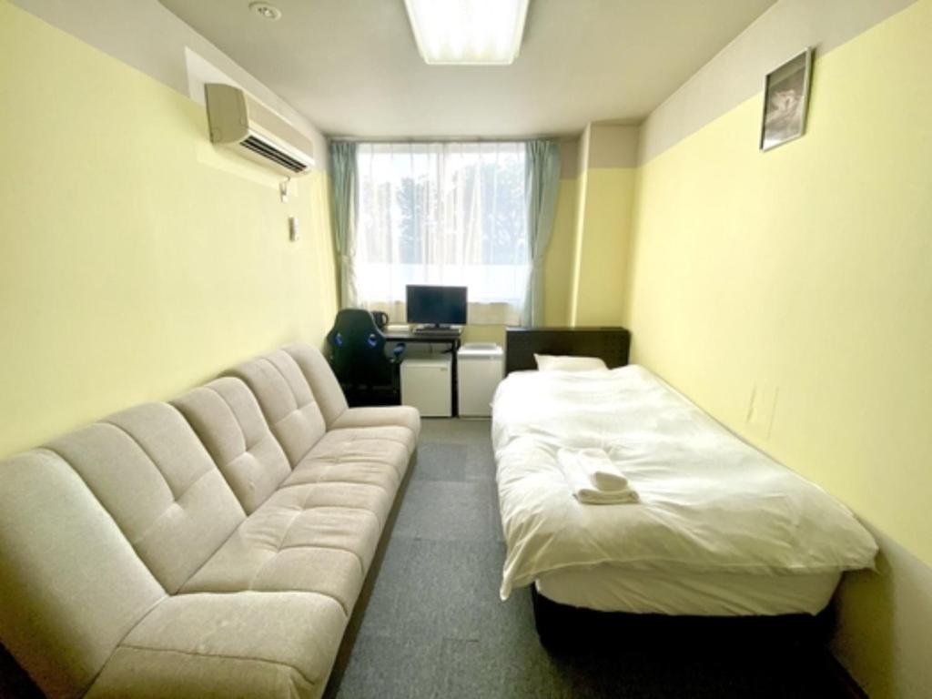 ein Wohnzimmer mit einem Sofa und einem Bett in der Unterkunft HDK Hotel - Vacation STAY 07718v in Tsu