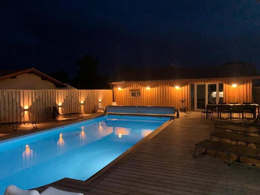 une piscine dans un jardin la nuit dans l'établissement Le petit paradis, à Gujan-Mestras