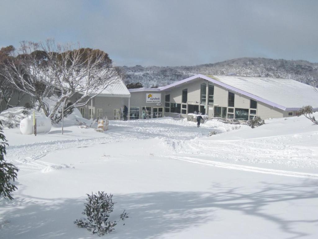 a snow covered yard with a building in the background at Sundeck Hotel in Perisher Valley