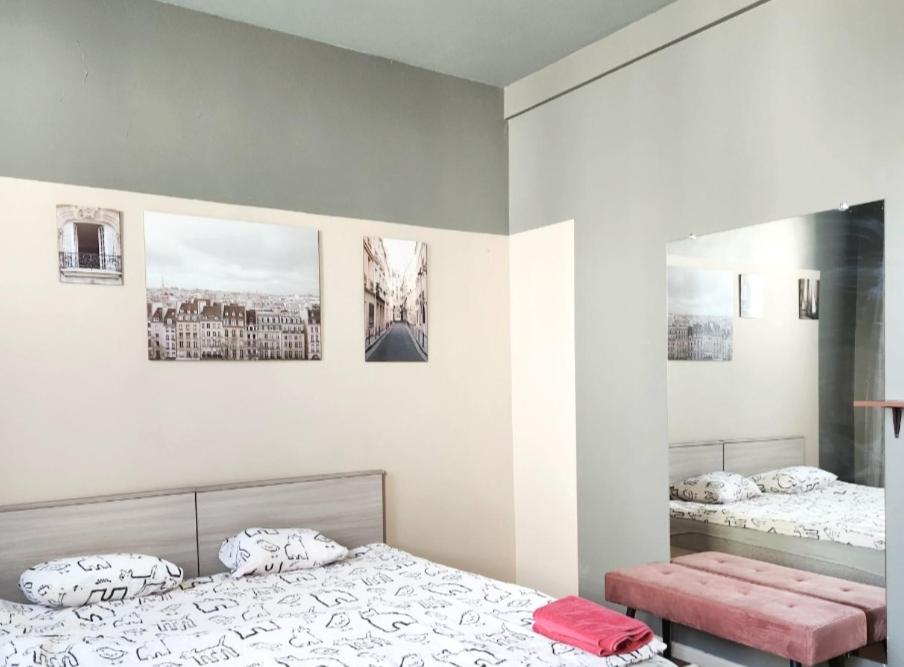 a bedroom with two beds and two pictures on the wall at Hostel Riga KVANT in Riga