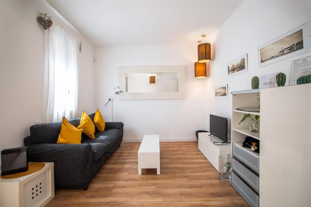 salon z czarną kanapą i żółtymi poduszkami w obiekcie P2VIL1042 Modern & Cozy Apartment Poble Sec w Barcelonie