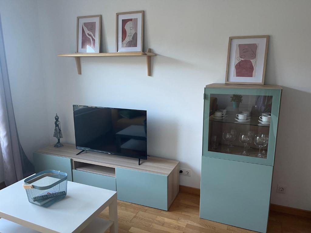 een woonkamer met een tv en een tafel bij Apartamento O Son in Cee