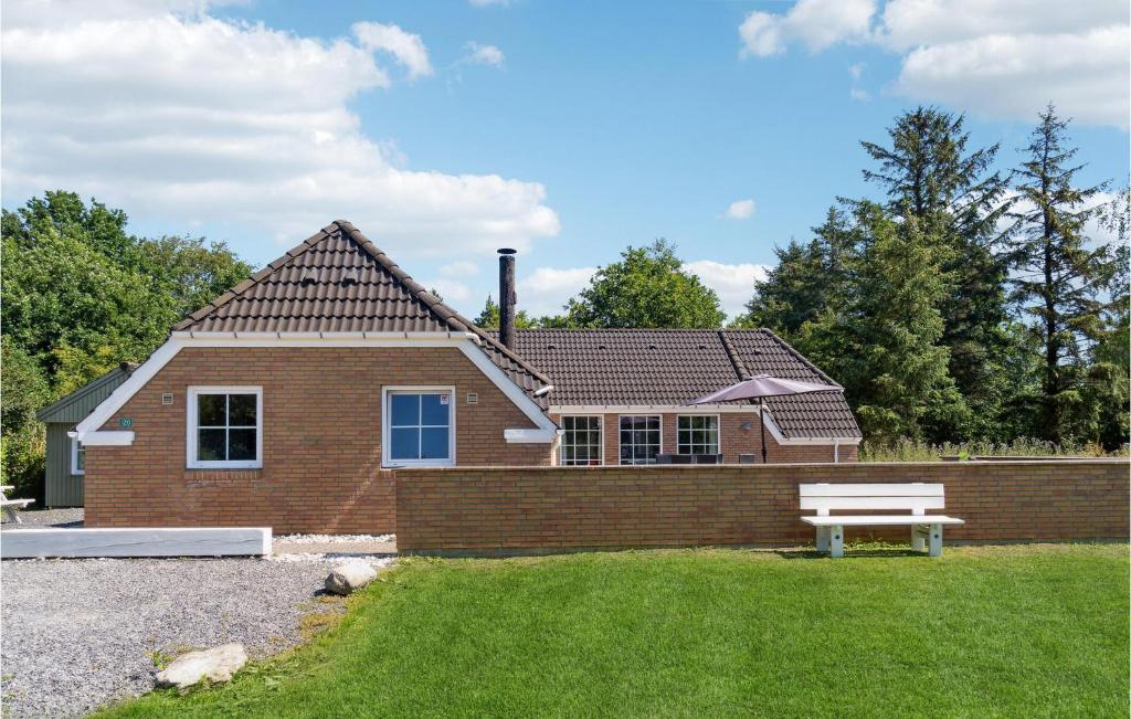 a brick house with a bench in front of it at Cozy Home In Oksbøl With Sauna in Oksbøl