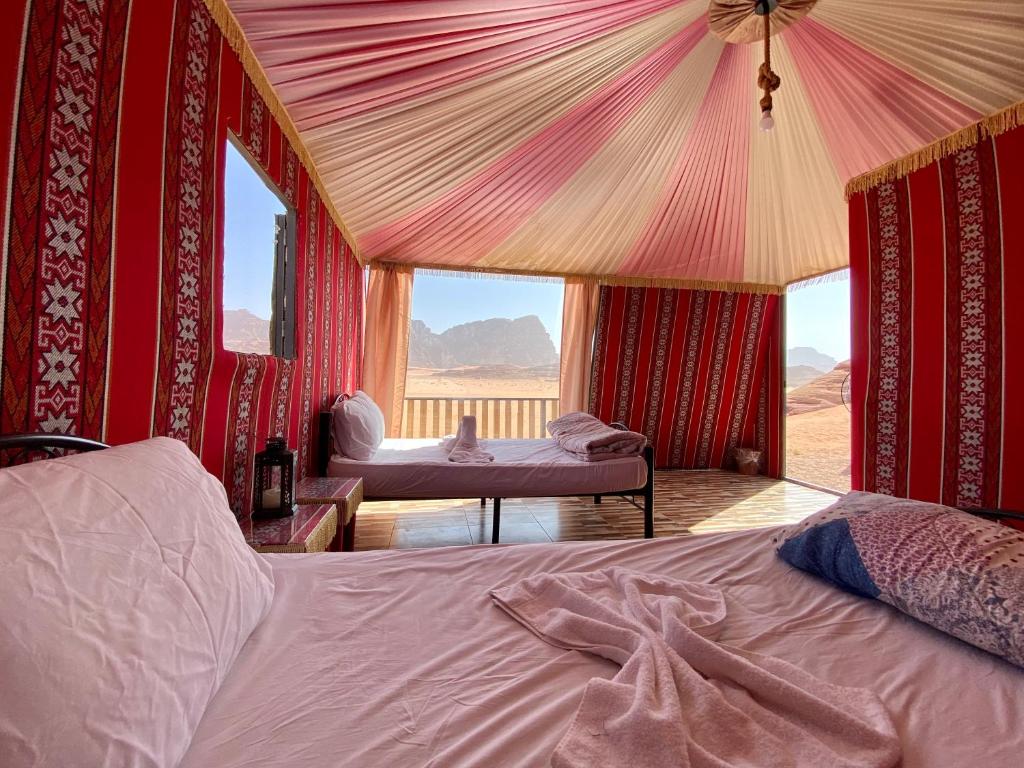 a bedroom with two beds and a view of the desert at Desert's Soul Wadi Rum in Disah