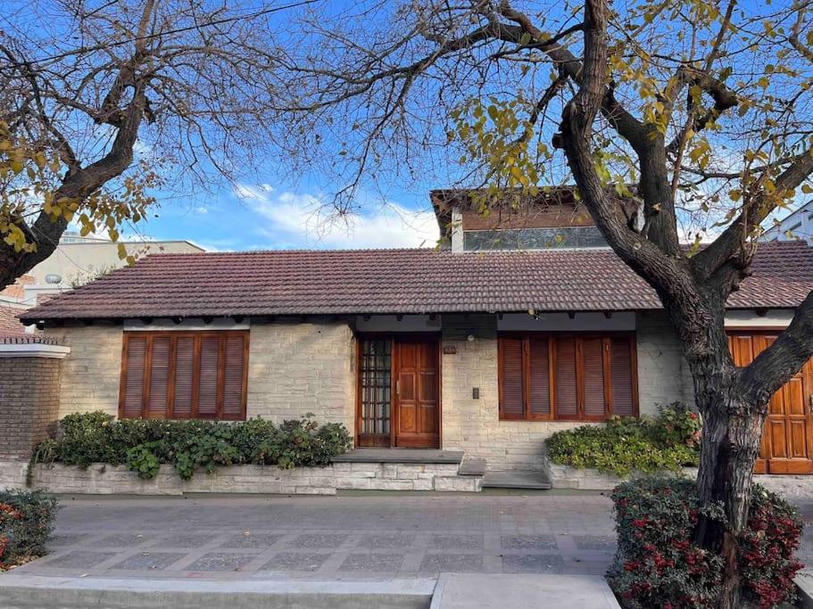 a brick house with a tree in front of it at Valentino House piscina internet parking desayuno in Mendoza