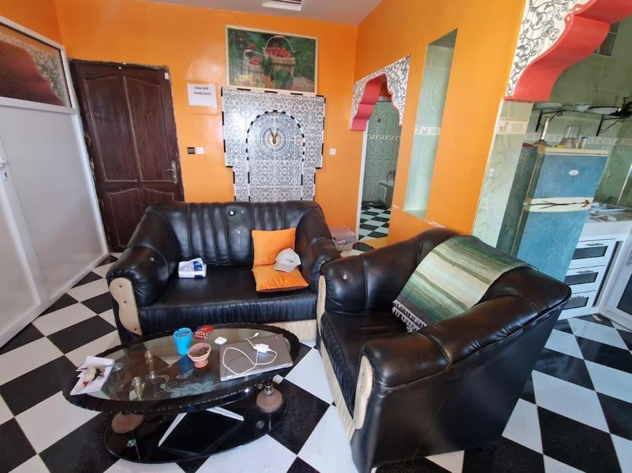 sala de estar con sofá de cuero y mesa en REPOS SURF HOUSE 2, en Sidi Ifni