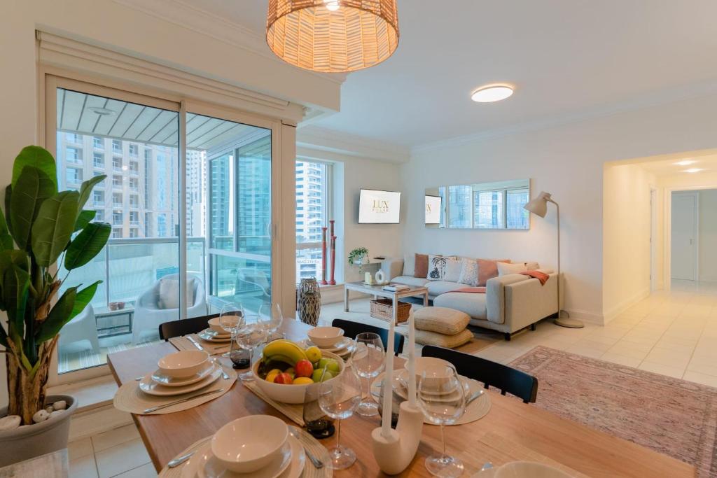 a dining room with a table with a bowl of fruit on it at LUXFolio Retreats - Astonishing 3BHk Apartment in Dubai