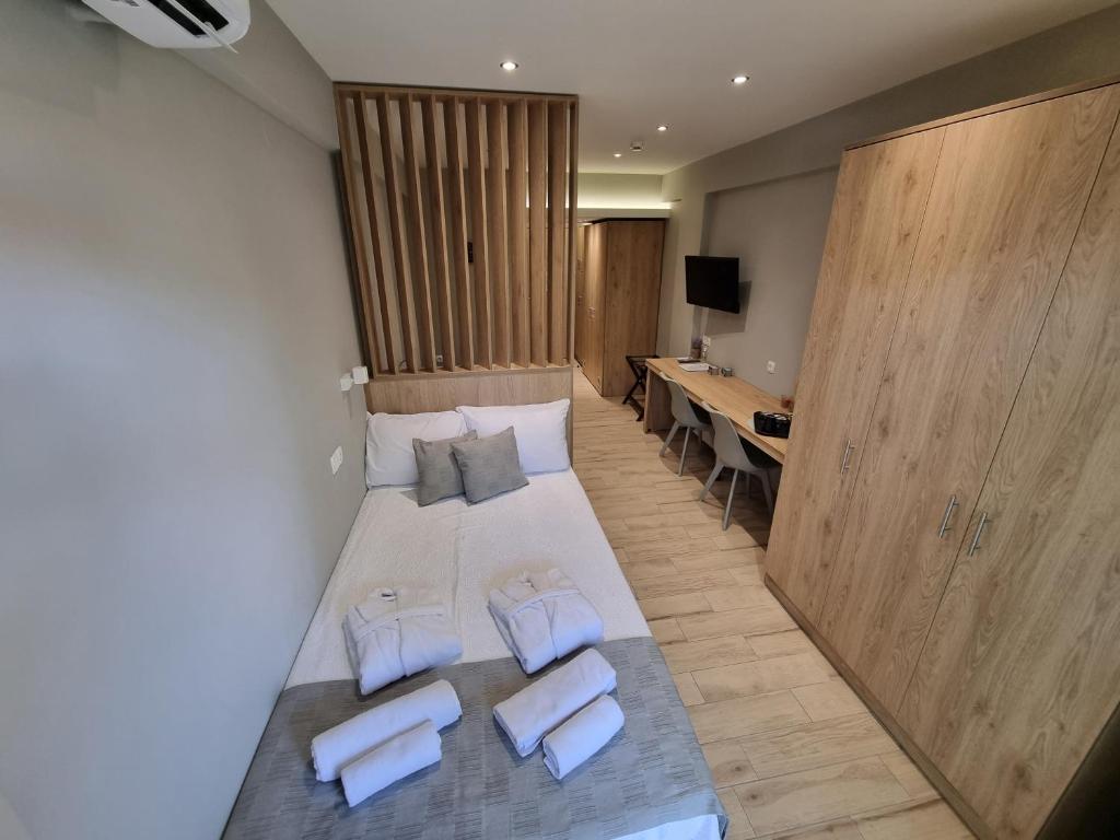 a bedroom with a bed with two pillows and a desk at Xanthi Apartments in Katerini