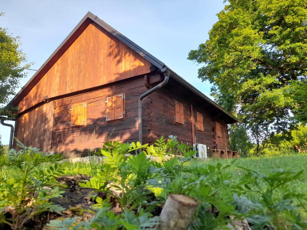 an old wooden barn in a field of plants at Peace Creek in Slunj