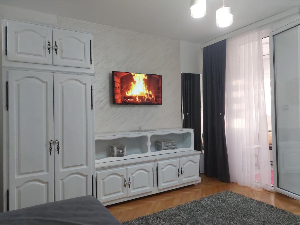 a white entertainment center with a tv on a wall at Studio Aleksandar in Novi Pazar