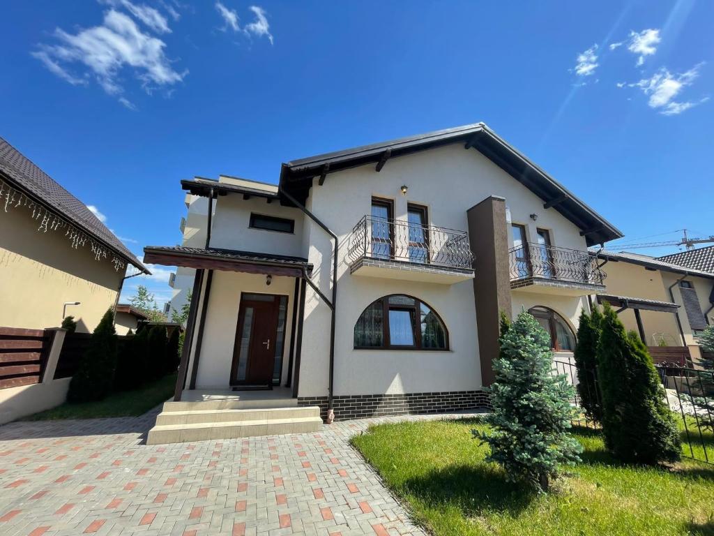 a large white house with a brick driveway at Vila Pati in Ploieşti