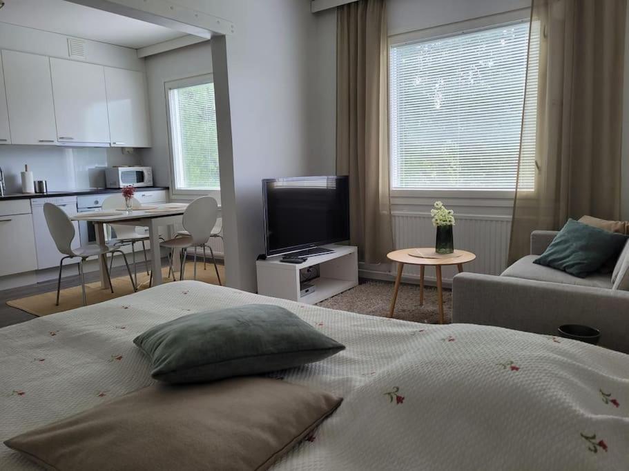 um quarto com uma cama, uma cozinha e uma sala de estar em Wäiönkatu 3 yksiö em Lappeenranta