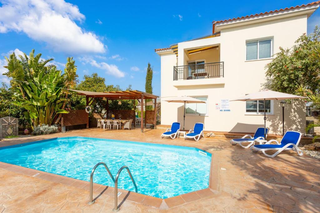 a villa with a swimming pool and a house at Villa Kleopatra in Paphos