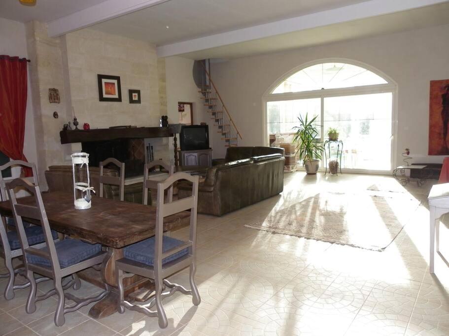 - un salon avec une table, des chaises et un piano dans l'établissement Maison de campagne avec piscine dans le bordelais, à Périssac