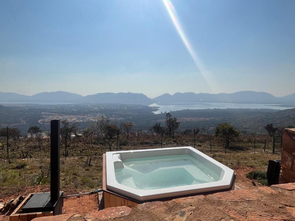 a bath tub sitting on top of a mountain at Rock House at Benlize in Hartbeespoort