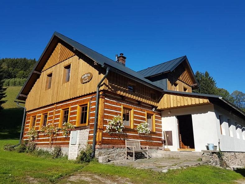 een groot houten huis met een zwart dak bij Horská chata Boubelka in Pec pod Sněžkou
