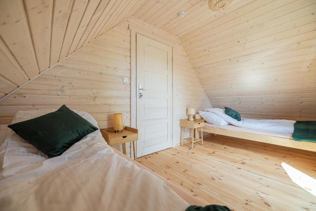 Postel nebo postele na pokoji v ubytování Natura Jantar - Całoroczne domy drewniane