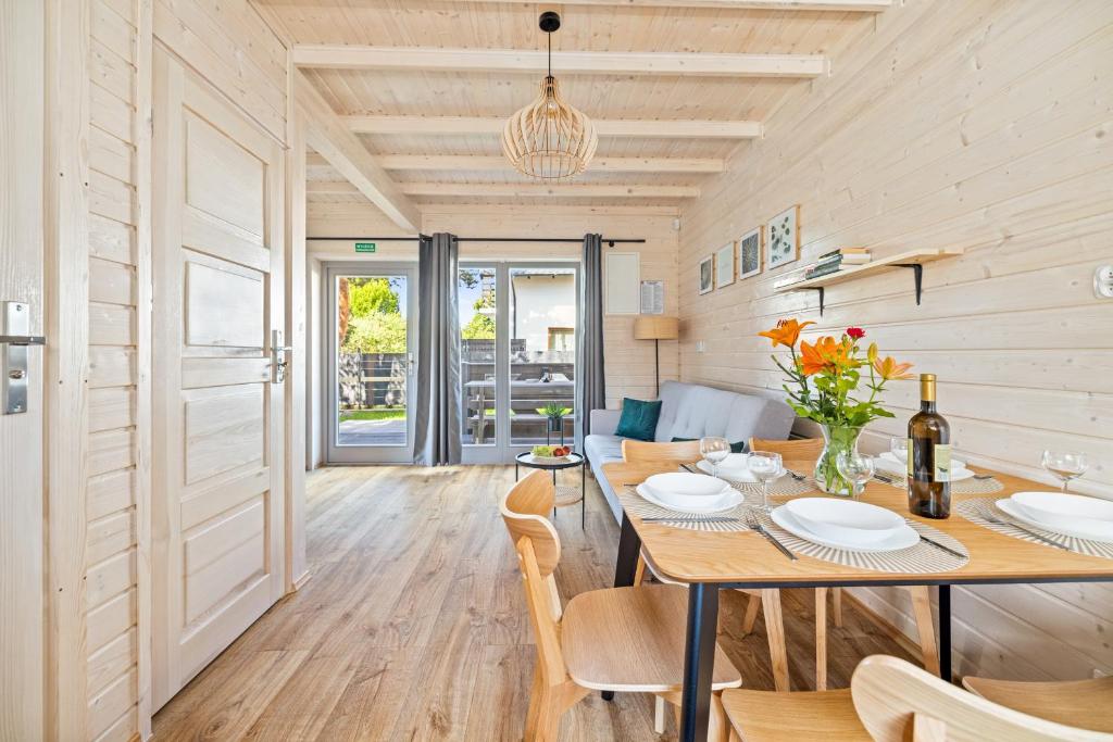 a dining room with a table and chairs at Natura Jantar - Całoroczne domy drewniane in Jantar