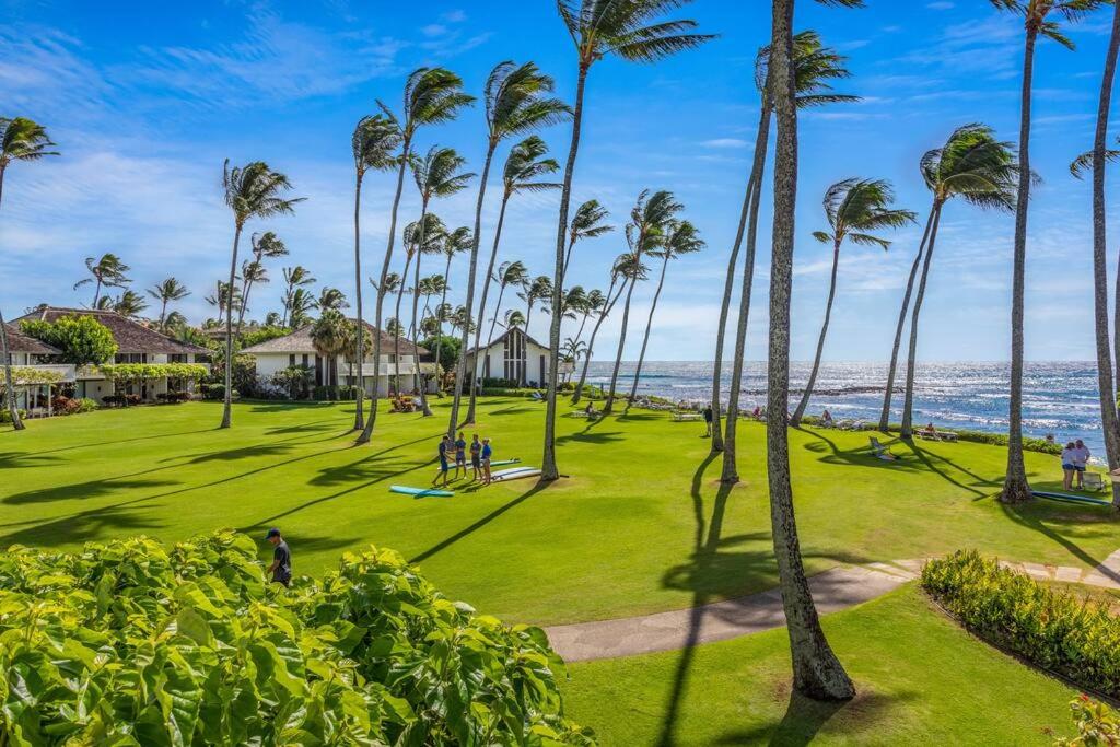 a park with palm trees and the ocean in the background at Kiahuna Plantation Kauai by OUTRIGGER - Select Your Unit in Koloa