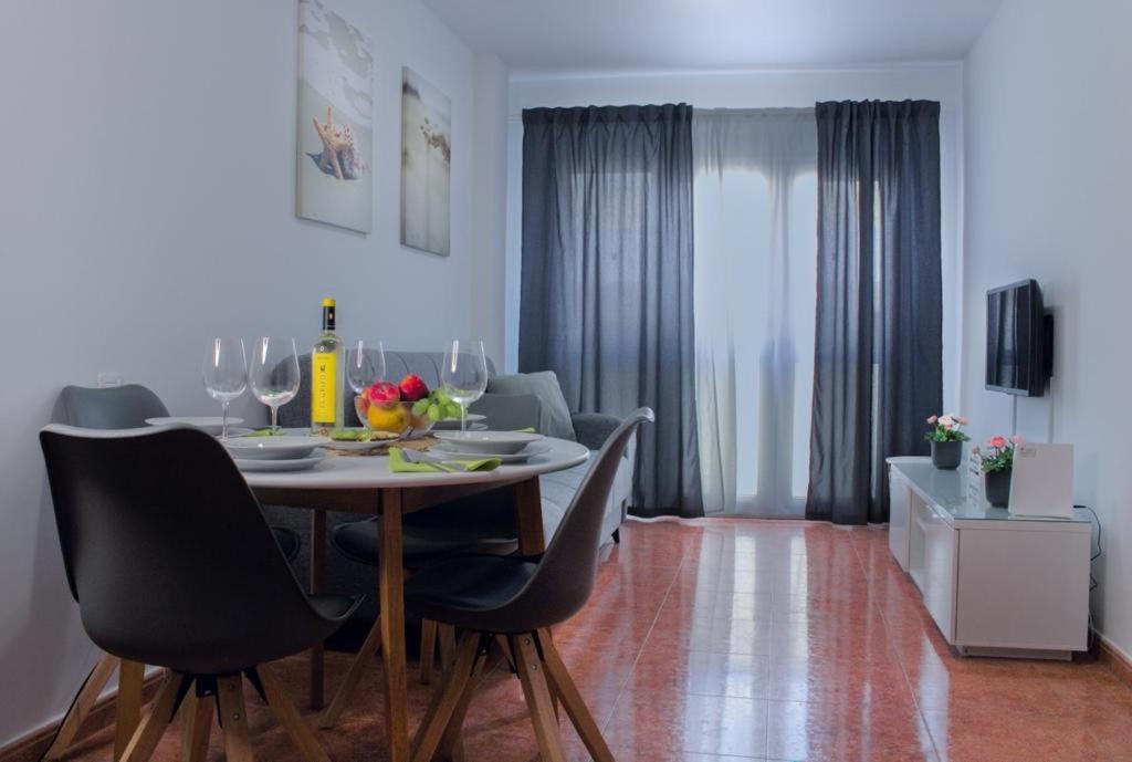 comedor con mesa y sillas con copas de vino en Apartamento Veronika en Arrecife