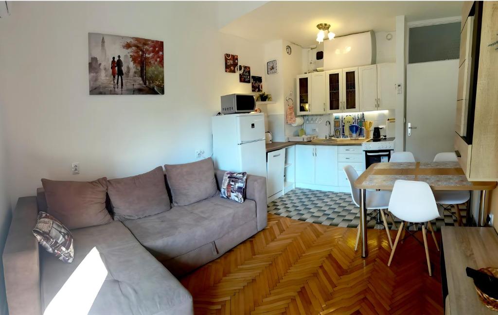 uma sala de estar com um sofá, uma mesa e uma cozinha em DLX Apartman Adriatics em Herceg Novi