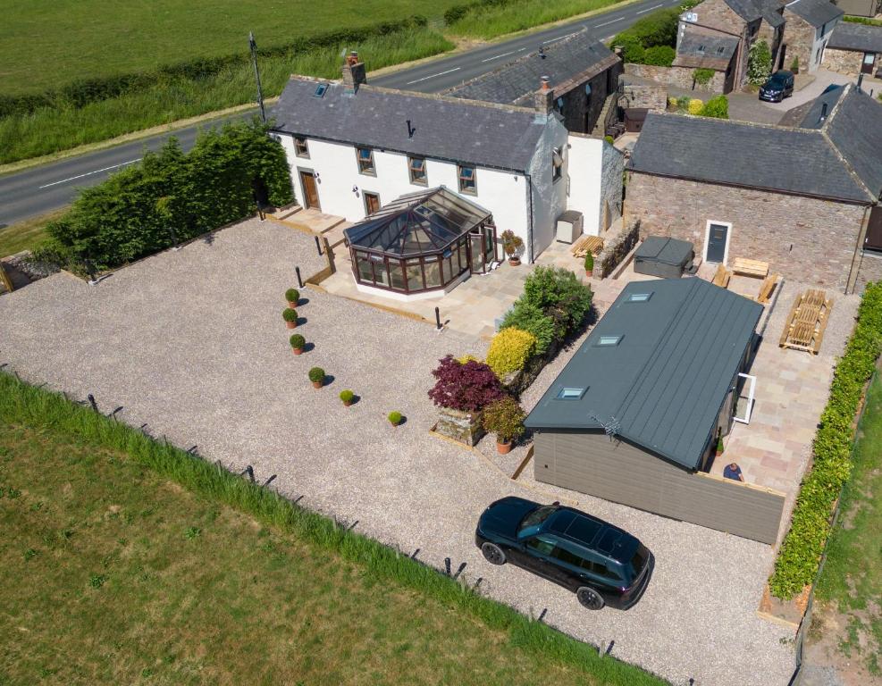 an aerial view of a house with a car parked in front at The Farmhouse, Sebergham, near Caldbeck in Sebergham