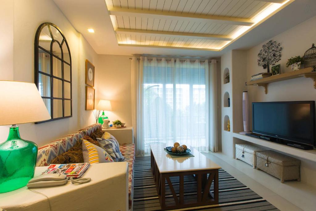 sala de estar con sofá y TV en Chelona 463 Khao Tao Condominium, en Khao Tao