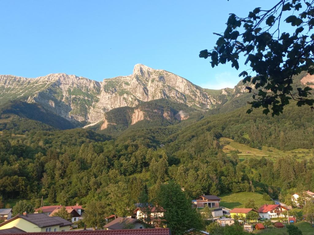 a mountain in the distance with houses and trees at Hiša za Gradom in Kobarid