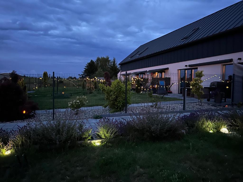 een gebouw met lichten in een tuin 's nachts bij Nowa Stodoła Koniec Świata in Mikołajki