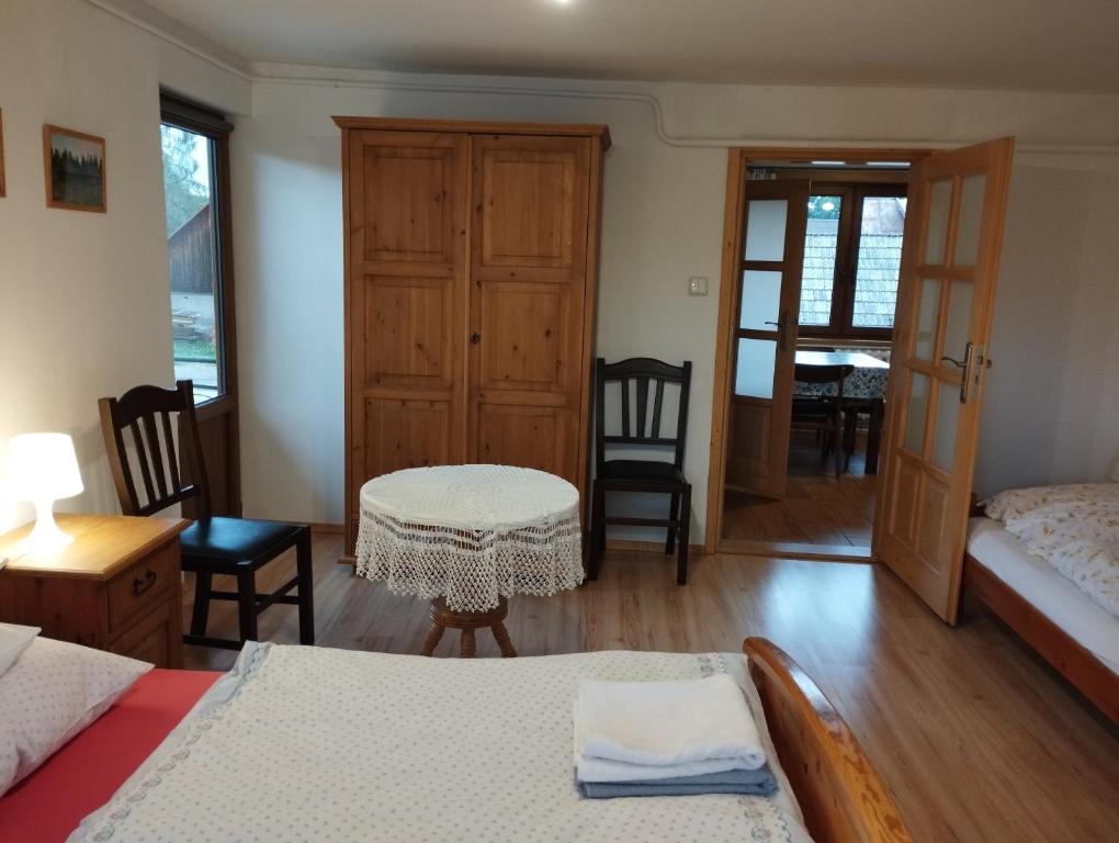 1 dormitorio con 2 camas, mesa y sillas en Pod limbą, en Jurgów