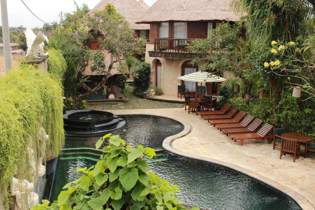 
a patio area with a pool and a bench at Dewani Villa Resort in Canggu
