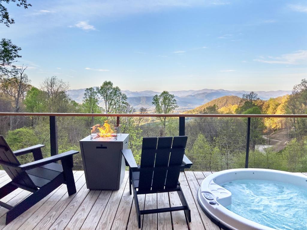 a deck with a jacuzzi tub and two chairs at The Glamping Collective in Clyde