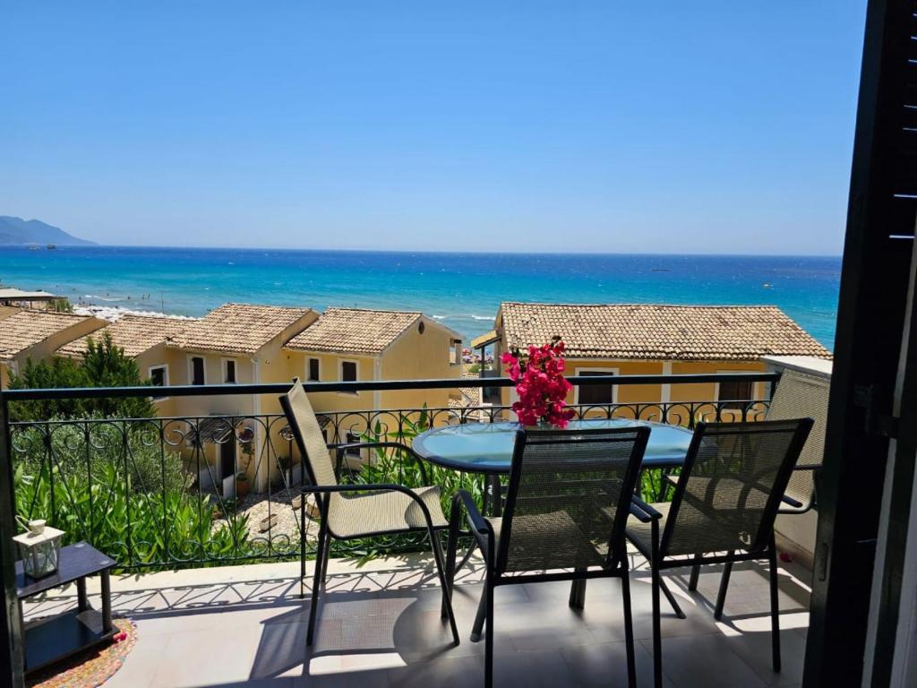 a table and chairs on a balcony with the ocean at Corfu Dream Holidays Villas Standarts in Glyfada