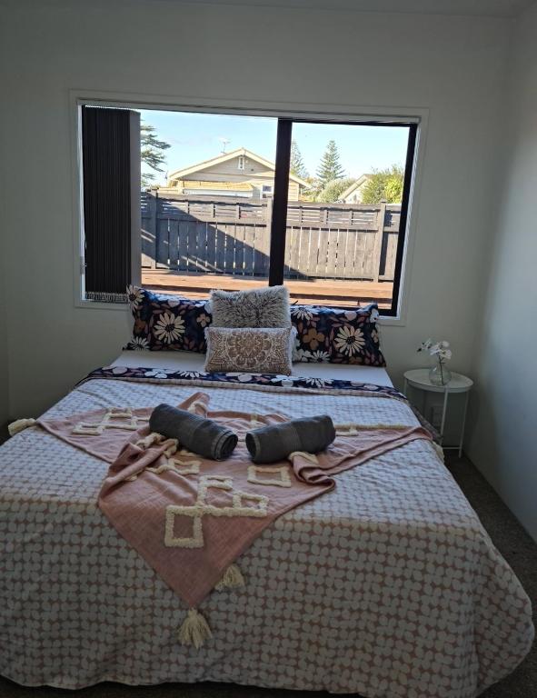 a bedroom with a large bed with a large window at Auckland airport holiday home in Auckland