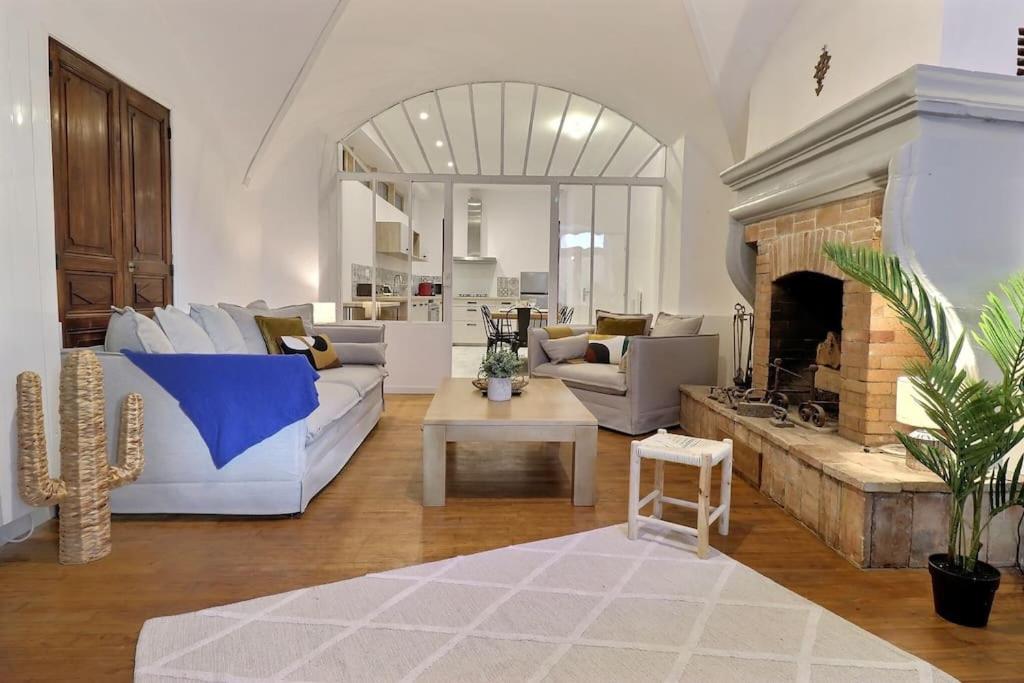uma sala de estar com mobiliário branco e uma lareira em La Veore - Baby-foot em Chabeuil