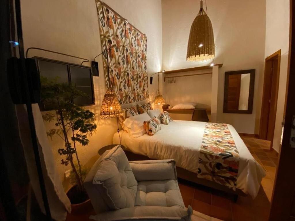 una camera con letto, sedia e divano di CasAlê Come&Dorme a São Pedro da Serra