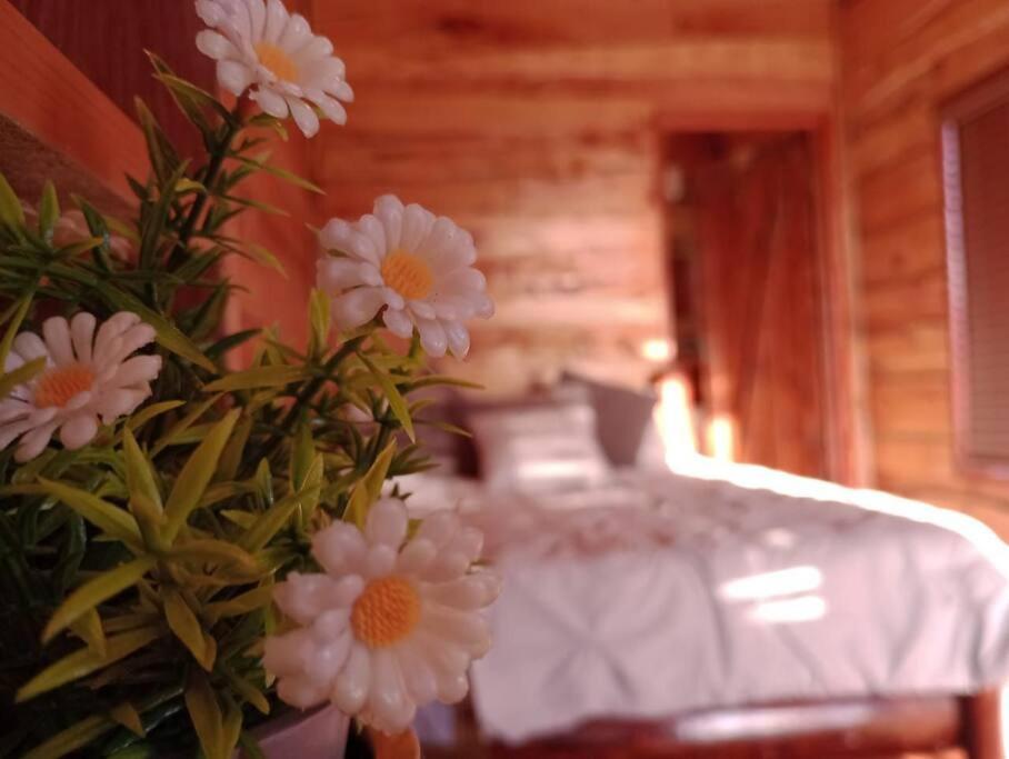 a vase filled with flowers next to a table at Finca La Gozadera in Jardín