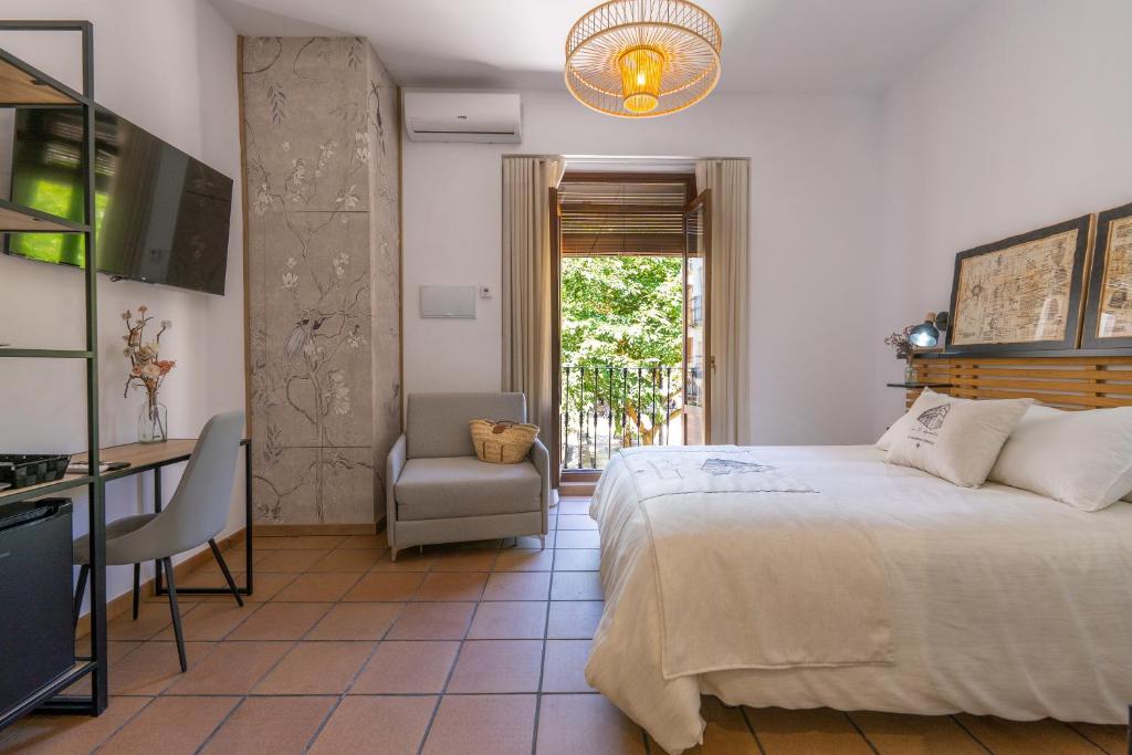1 dormitorio con cama, escritorio y silla en Casa el Aguardentero en Alcalá la Real