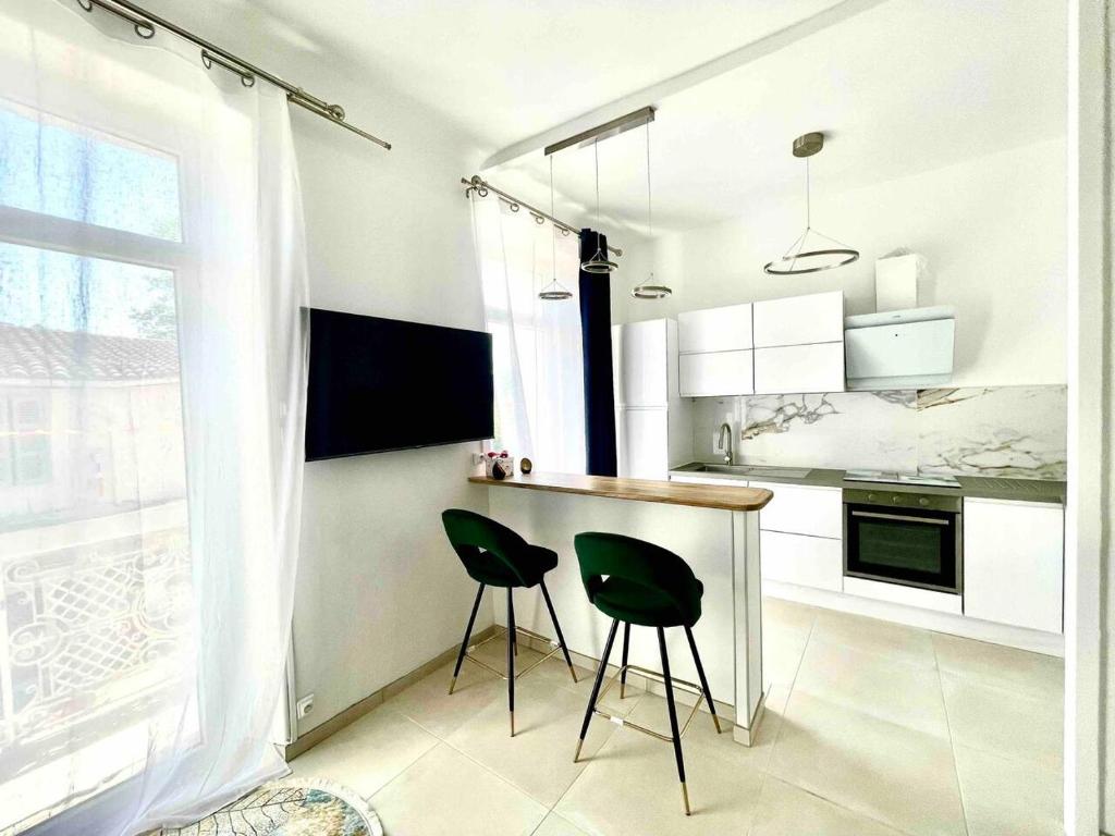 eine Küche mit zwei grünen Stühlen und einer Theke in der Unterkunft Le Malezi au du village des Pennes Mirabeau in Les-Pennes-Mirabeau