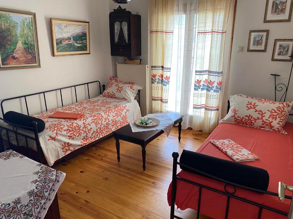 a room with two beds and a table and a window at ANASTASIAS HOUSE in Agios Nikolaos