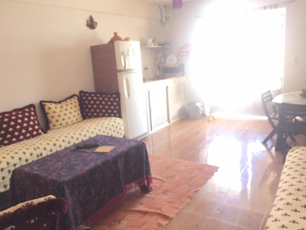 uma sala de estar com um sofá e um frigorífico em Villa Said em Moulay Bousselham