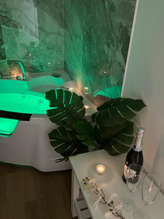 ein grünes Bad mit einer Badewanne und einer Flasche Wein in der Unterkunft AGF Luxury Apartment in Catania