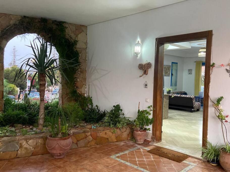 a living room with a stone wall and a doorway with plants at Plage à portée: Appart. paisible in Skhirat