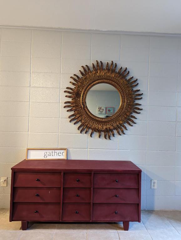 a mirror on a wall with a red dresser at Pet friendly single story garden condominium in Gulfport