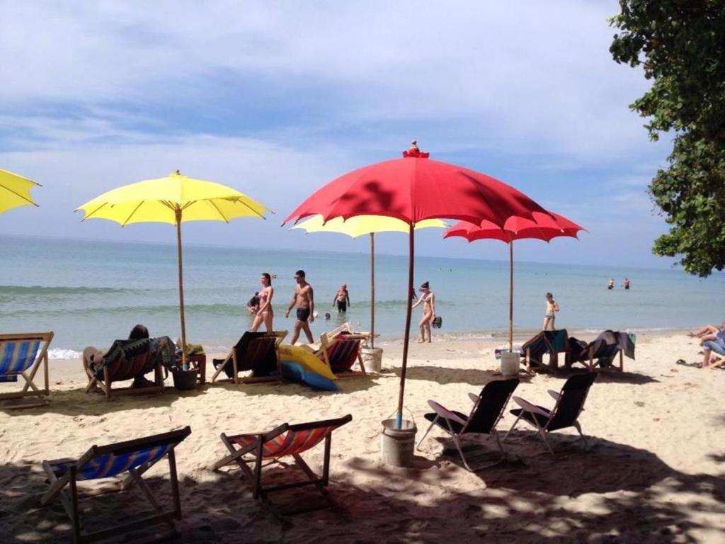 eine Gruppe von Menschen, die am Strand mit Sonnenschirmen sitzen in der Unterkunft Sangtawan Resort in Ko Chang
