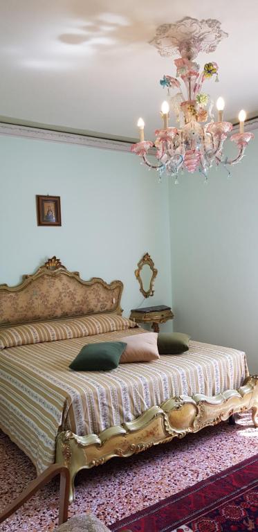 a bedroom with a large bed with a chandelier at Da Emi E Giuly in Mestre