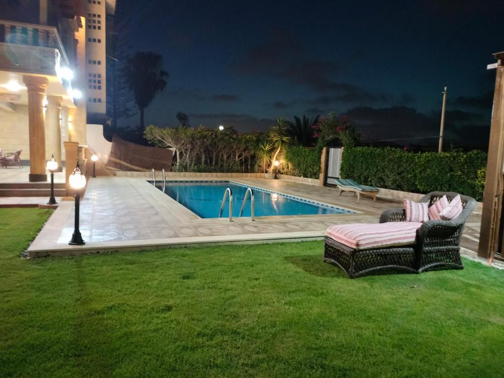 ein Schwimmbad in einem Garten in der Nacht in der Unterkunft فيلا للايجار في مارينا 4 حمام سباحة خاص in El-Alamein